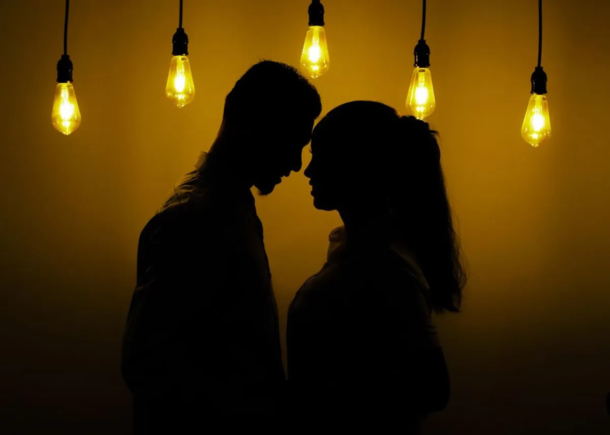 Couple close together in warm light, curious and connected