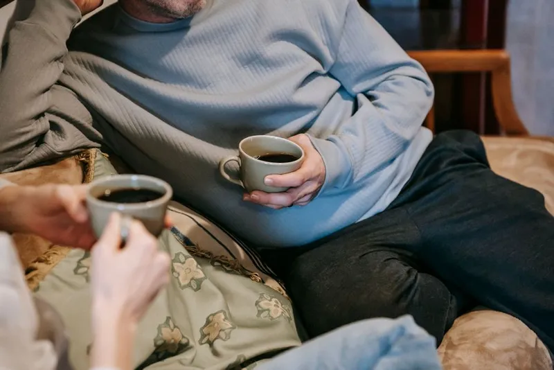 Couple sitting together on a sofa, relaxed and unhurried