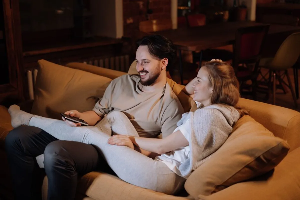 Couple relaxing together at home in warm evening light