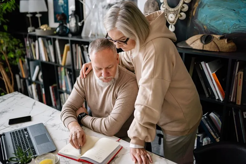 Couple sitting together at home making plans in warm evening light