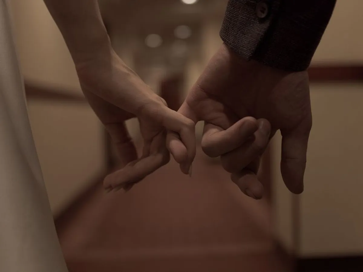 Two hands held gently together in soft light