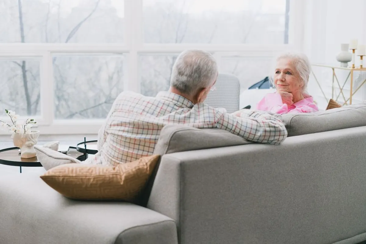 Couple in a calm, gentle conversation on a sofa at home