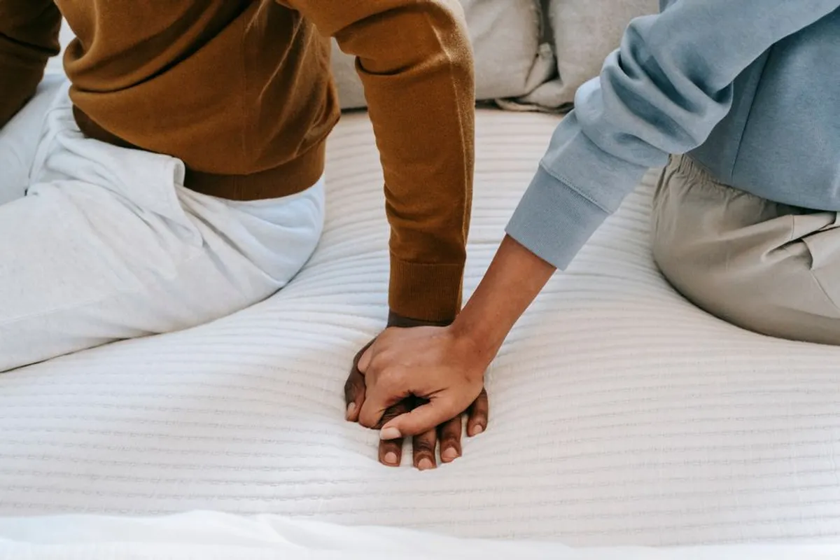 Couple holding hands gently in warm light