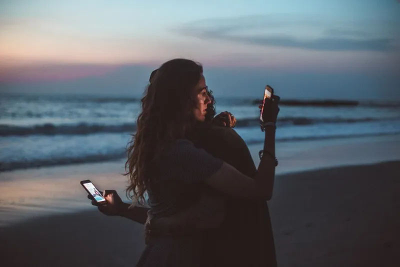 Two people answering privately on their phones at home