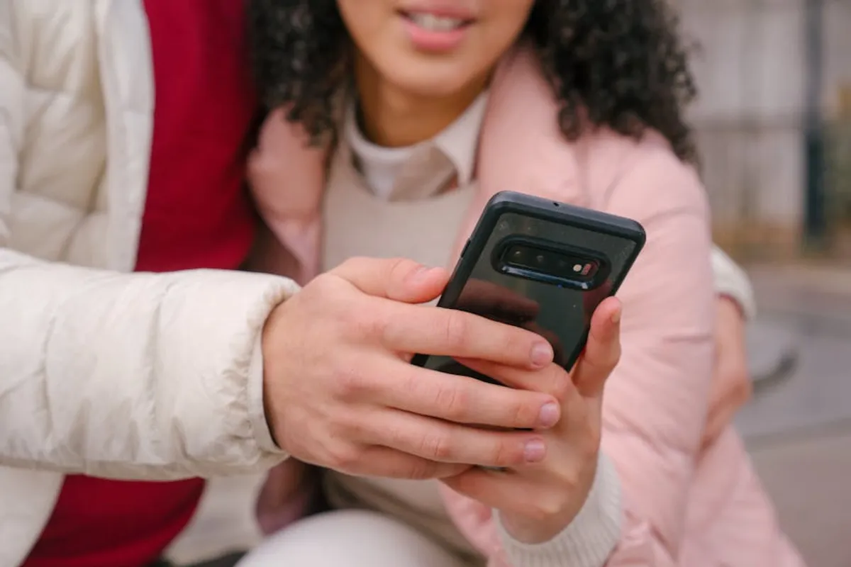 Couple close together looking at a phone