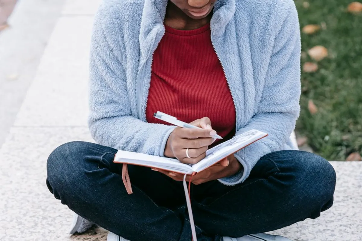 Person writing privately in a notebook