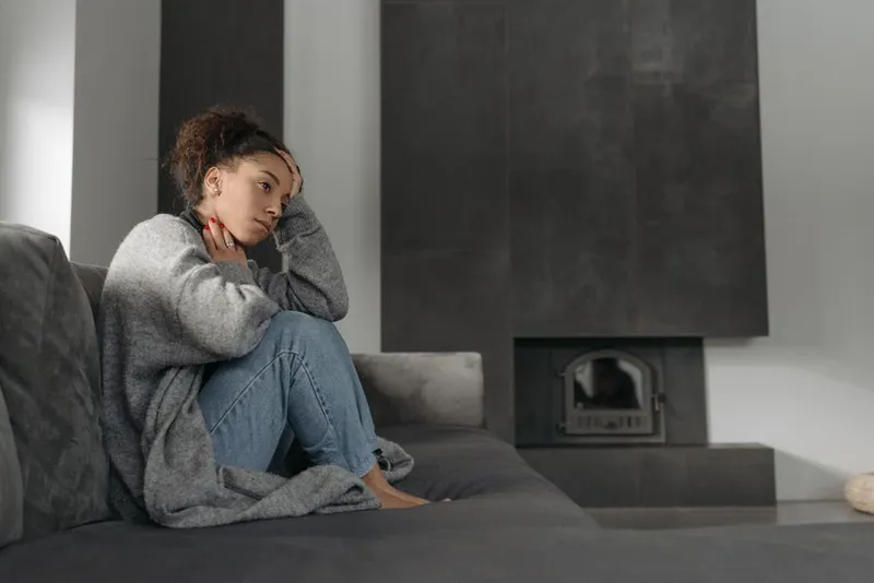 Woman sitting alone on a sofa, quiet and tired