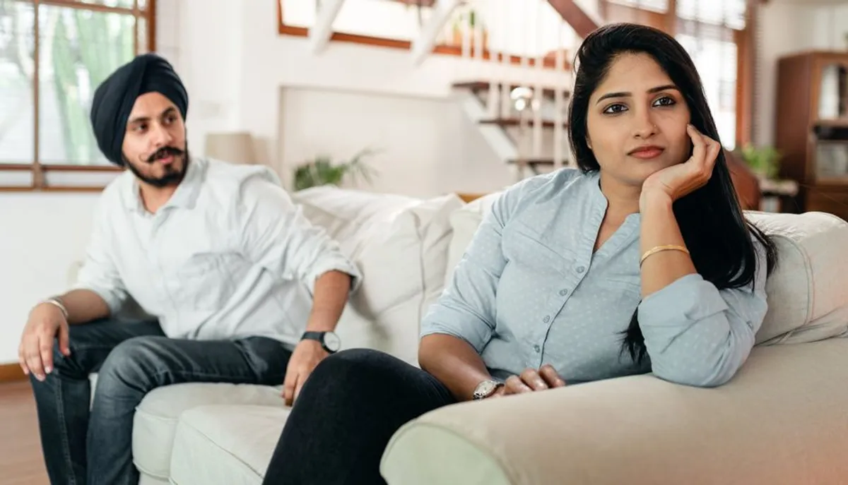 Couple sitting quietly apart on a sofa