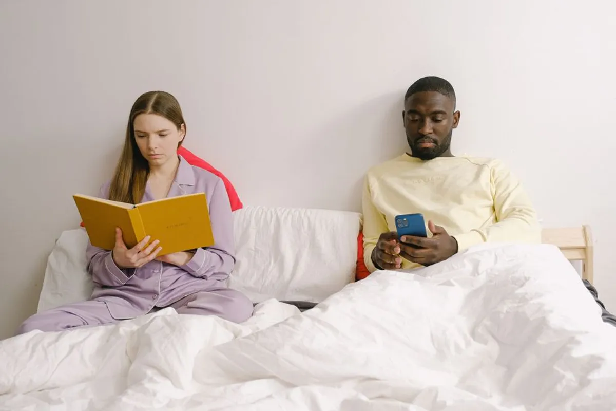 Couple reading separately in bed