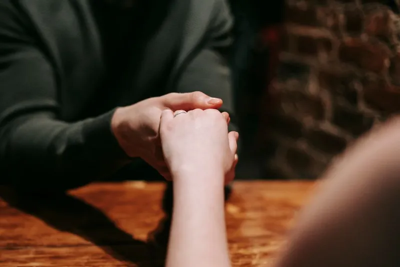Two hands held gently together in warm, soft light