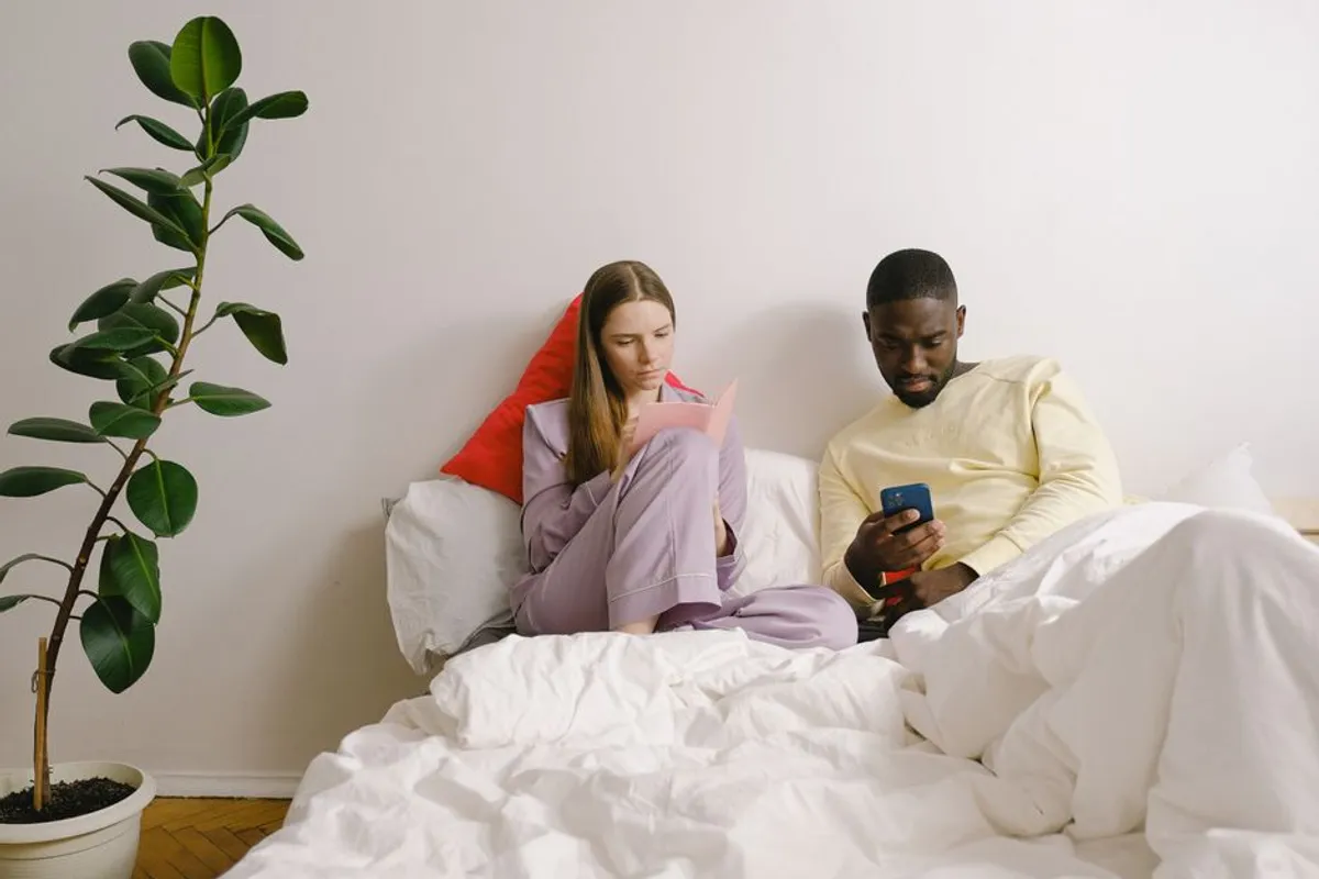 Couple calmly using their phones at home