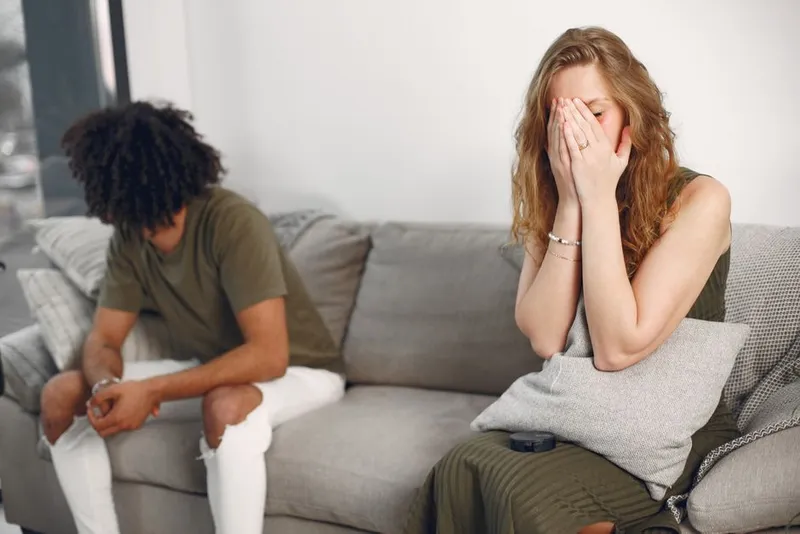Couple sitting quietly apart on a sofa