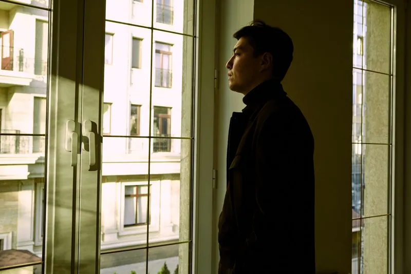 Person sitting quietly by a window in soft light